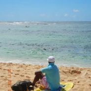 Dj Mizzy sitting on the beach in Kaui